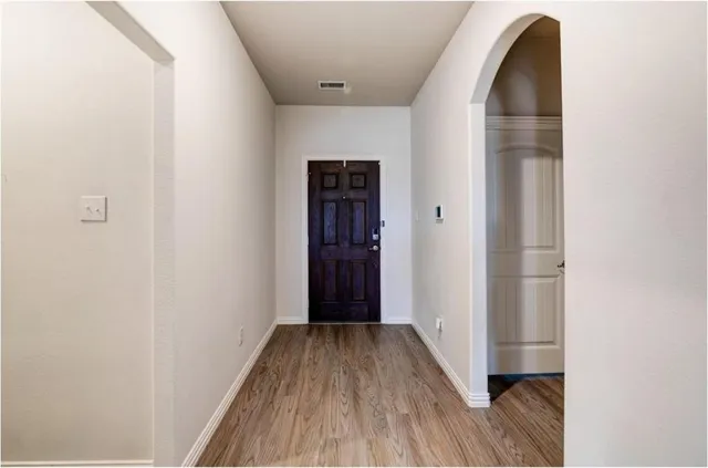 a view of a hallway with wooden floor and entryway