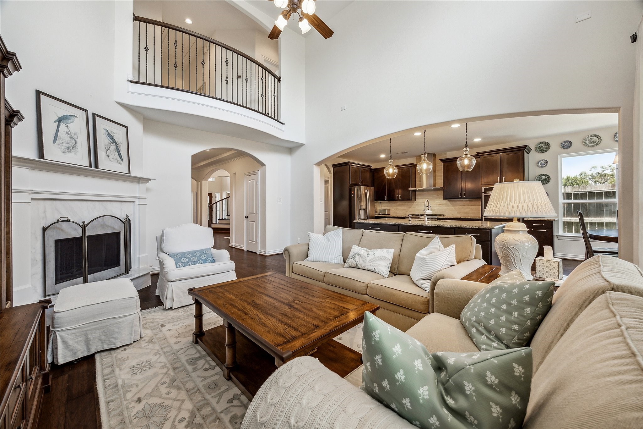 1515 Thornton Road Houston, TX 77018 - Photo 10 of 39 As you continue through the foyer corridor, you arrive at the primary living room of the home, boasting impressive architectural elements such as a double-height coffered ceiling and a wide-span arch leading into the kitchen area. Beautiful wood floors and large windows overlooking the private patio and backyard compliment this lovely, sunlit space.