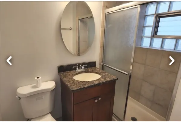 a bathroom with a granite countertop sink toilet and a mirror
