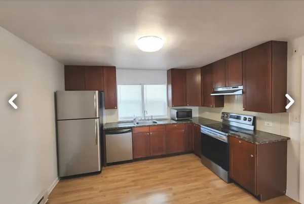 a kitchen with stainless steel appliances granite countertop a refrigerator a sink dishwasher a stove with wooden cabinets and floor