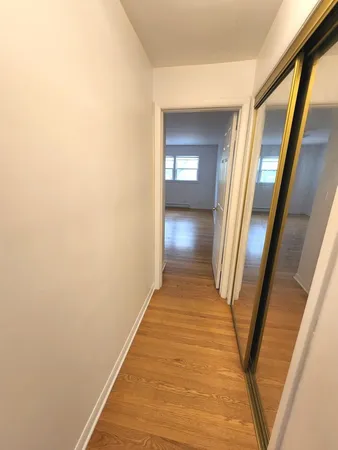 a view of a hallway with wooden floor and staircase