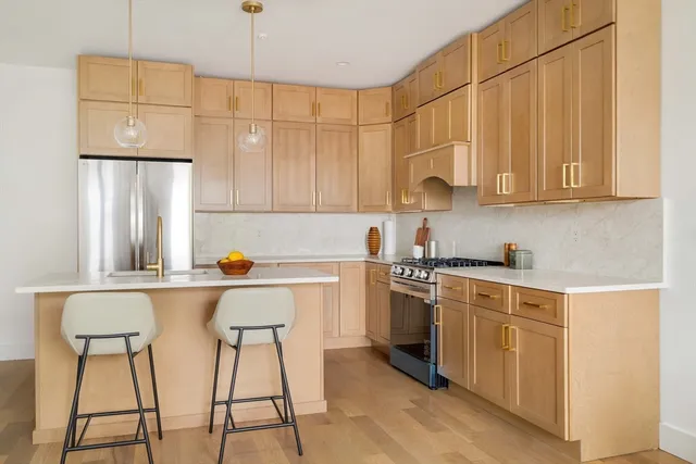 a kitchen with stainless steel appliances a stove a sink cabinets and a refrigerator