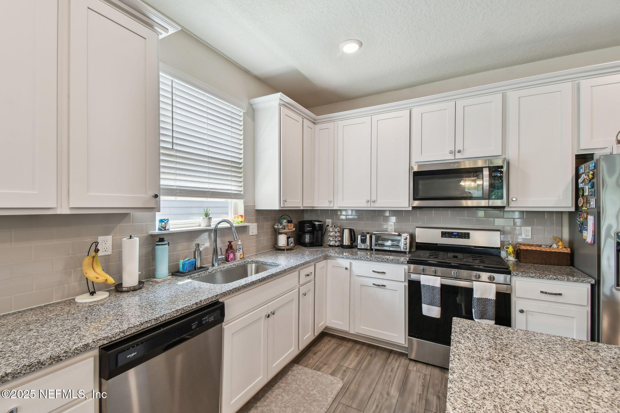 182 Myrtle Oak Court St. Augustine, FL 32092 - Photo 15 of 81 a kitchen with stainless steel appliances granite countertop a stove a sink dishwasher and a microwave oven with white cabinets