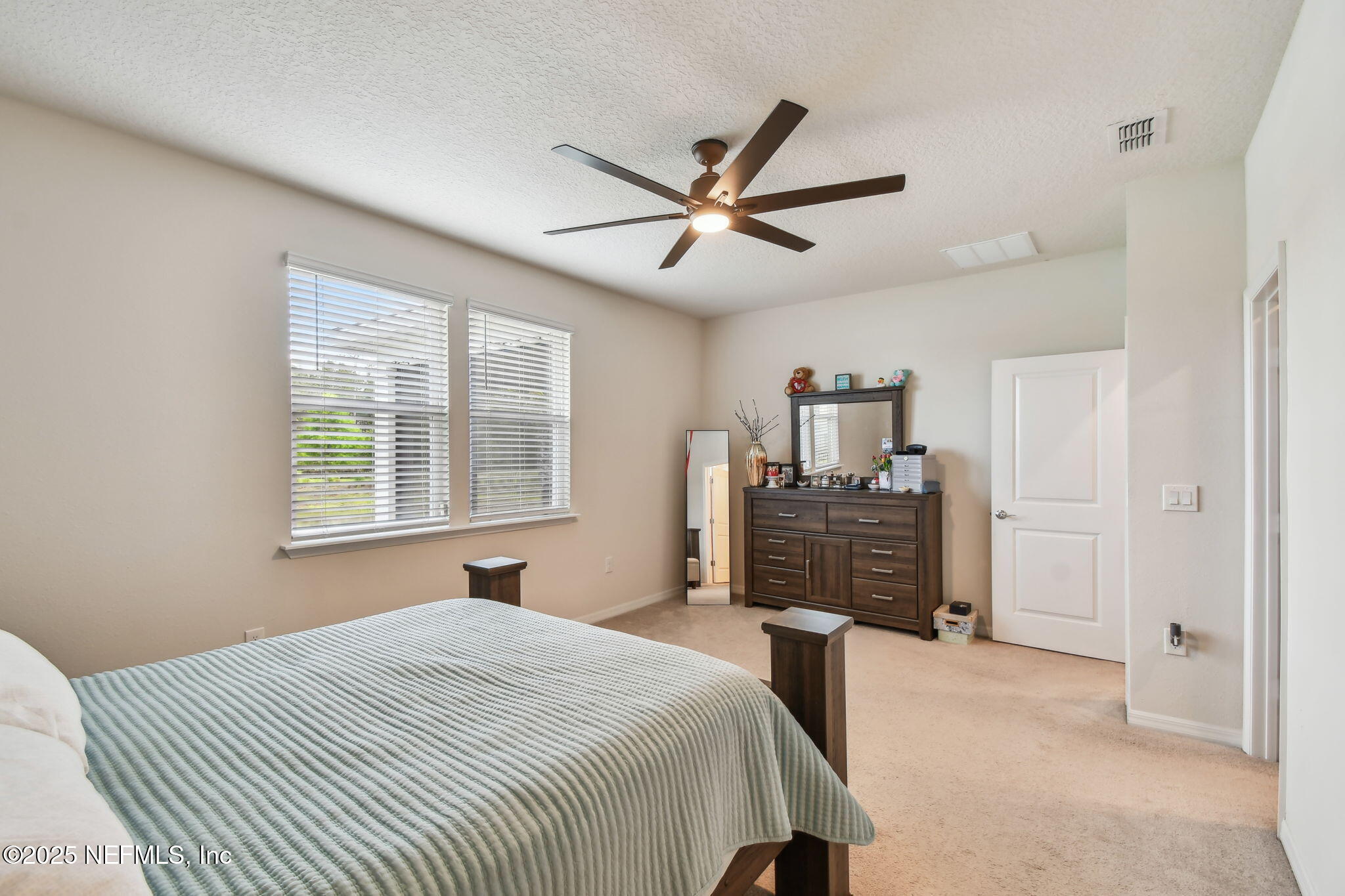 182 Myrtle Oak Court St. Augustine, FL 32092 - Photo 25 of 81 a bedroom with a bed and dresser with mirror
