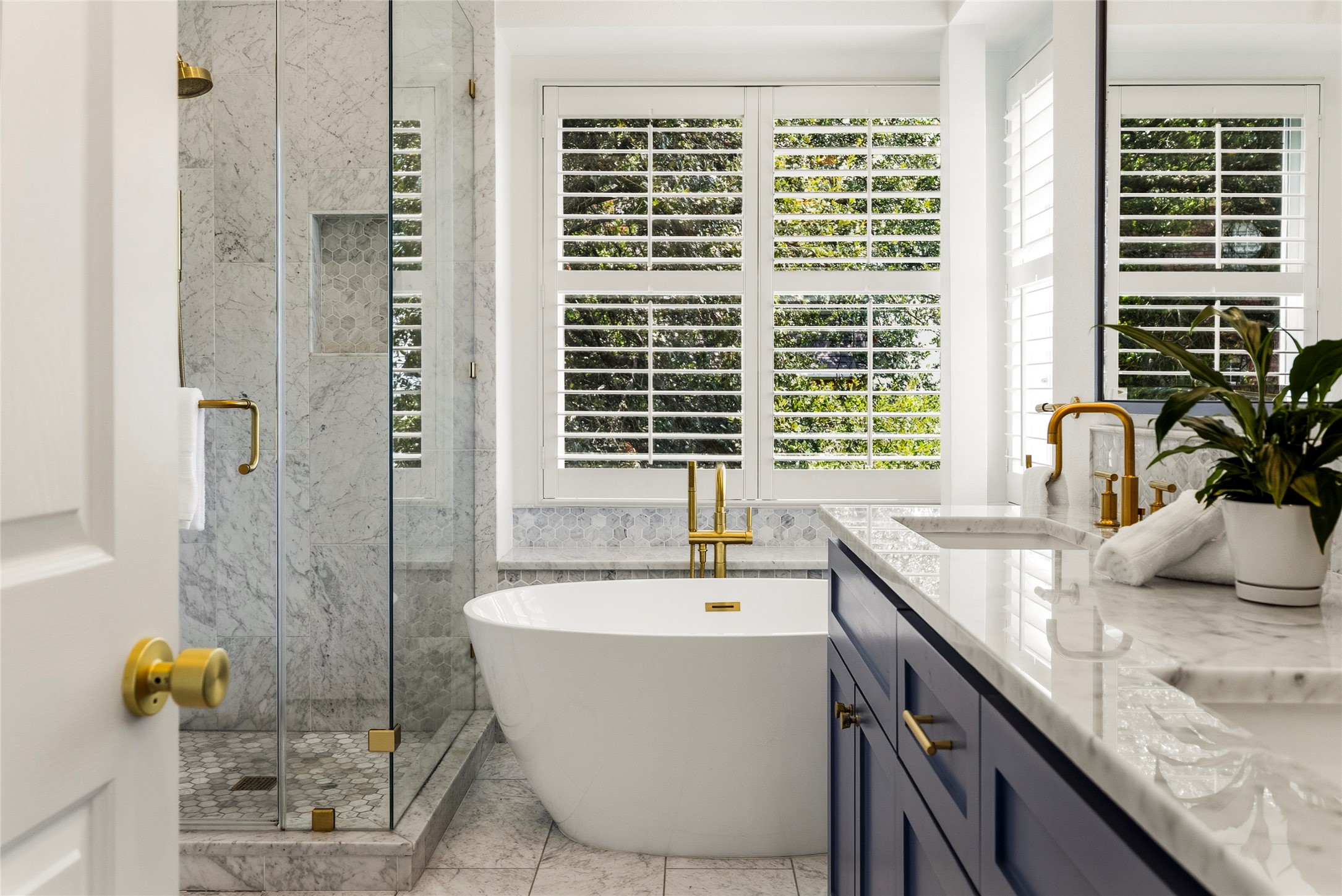 3107 Lookout Lane Austin, TX 78746 - Photo 24 of 39 Marble finishes and golden fixtures elevate this serene primary bathroom's luxurious appeal.