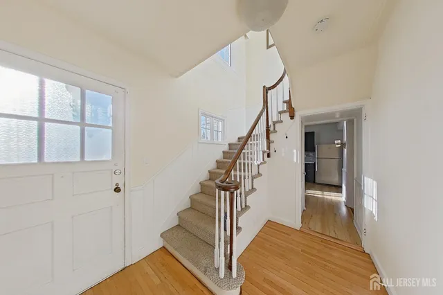 a view of entryway and hall with wooden floor