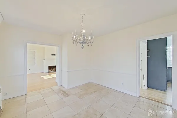 a view of a hallway with wooden floor and chandelier