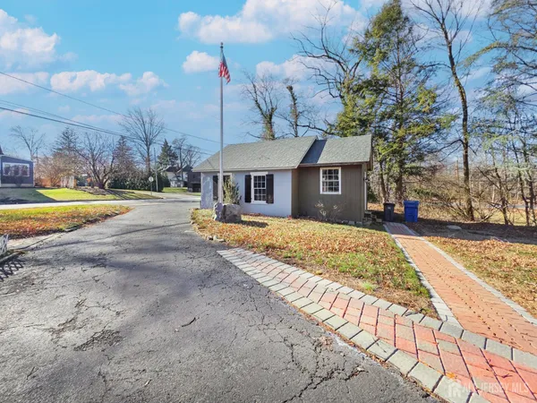 a front view of a house with a yard and trees