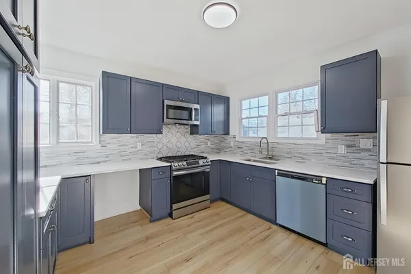 a kitchen with stainless steel appliances granite countertop a sink stove and cabinets