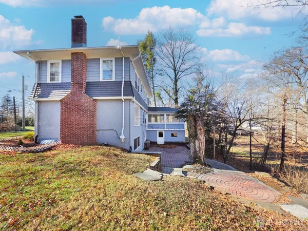 a brick house that has a tree in front of it