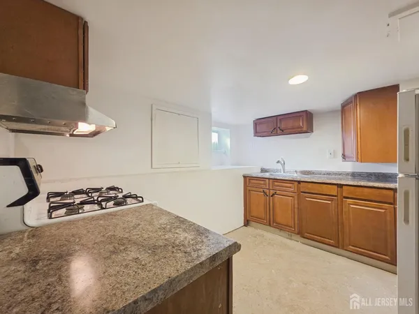 a kitchen with stainless steel appliances granite countertop a refrigerator a stove a sink and a microwave