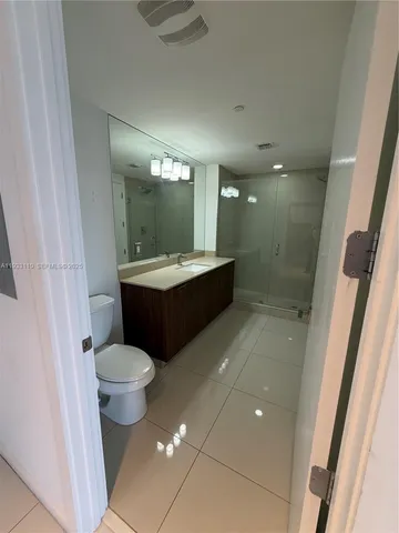 a bathroom with a sink toilet a mirror and shower