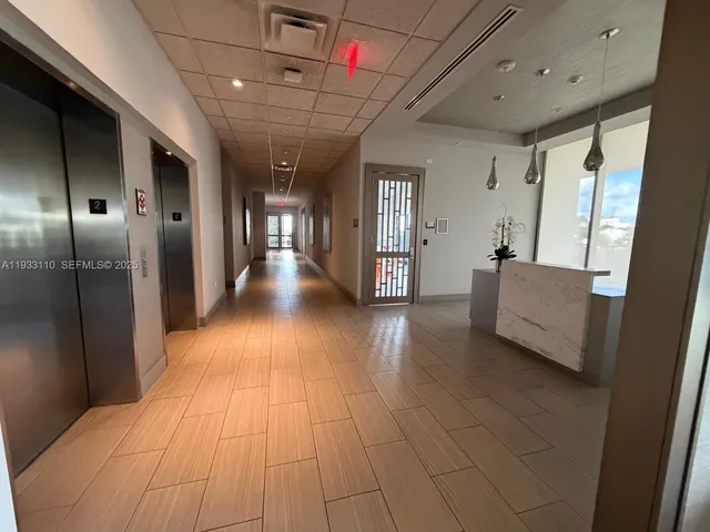 a view of a hallway with the couches and chandelier