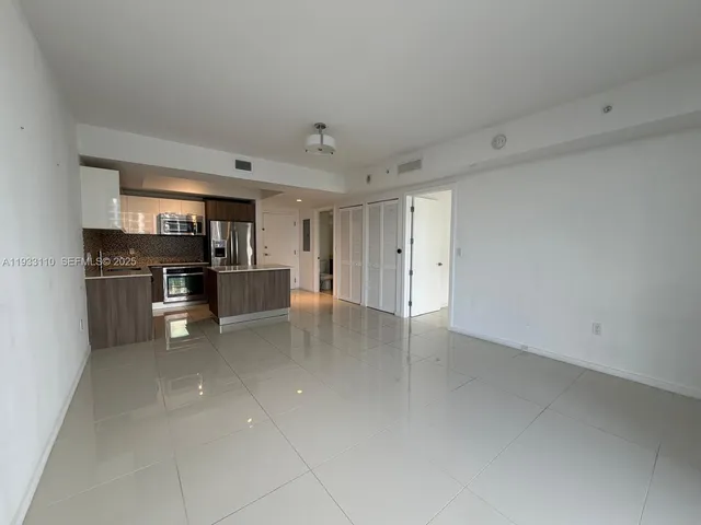 a view of a kitchen with refrigerator and chairs
