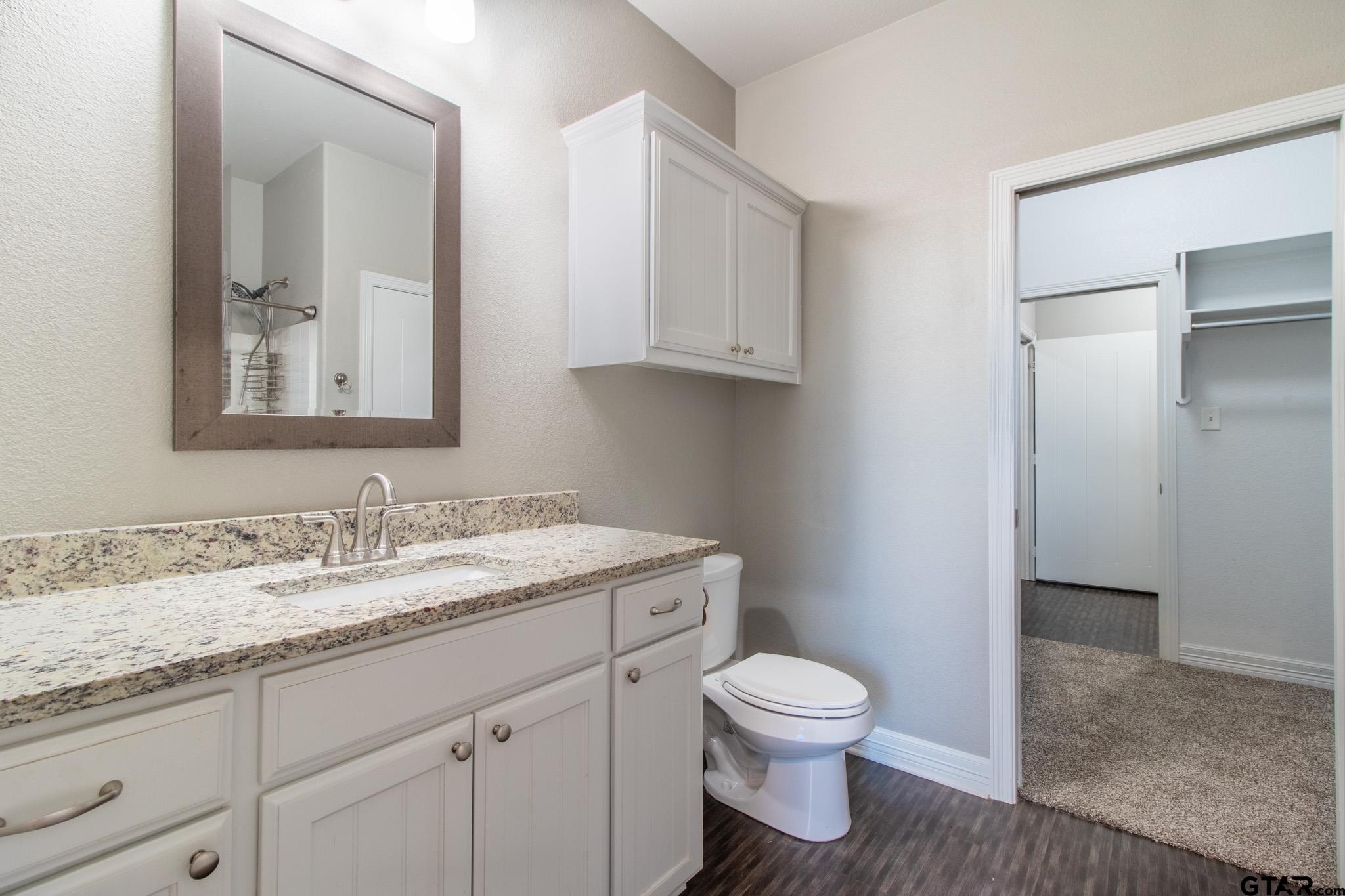 2806 Valley View Street Tyler, TX 75701 - Photo 12 of 22 a bathroom with a granite countertop toilet sink and mirror