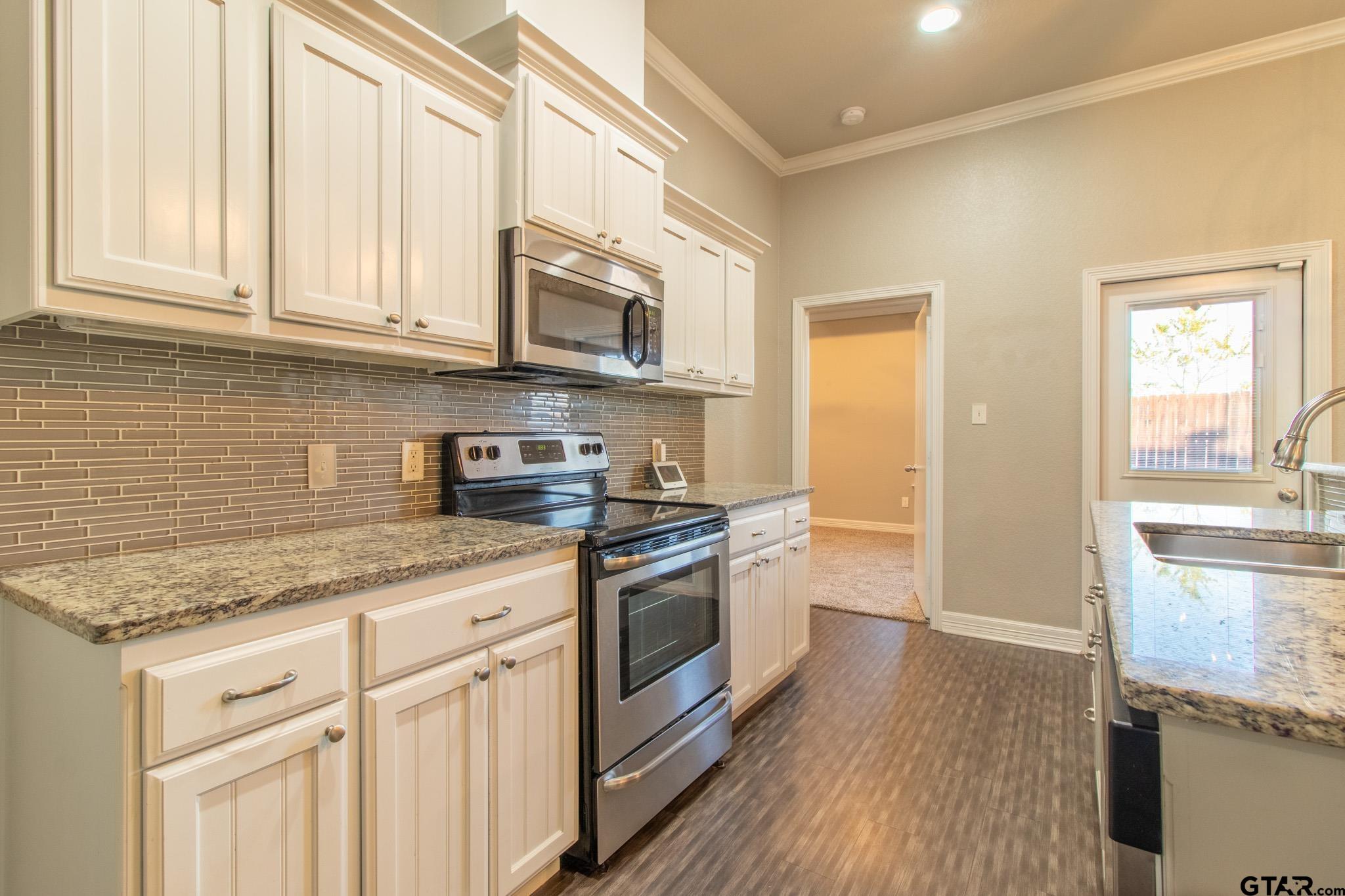 2806 Valley View Street Tyler, TX 75701 - Photo 7 of 22 a kitchen with stainless steel appliances granite countertop a stove a sink and a microwave