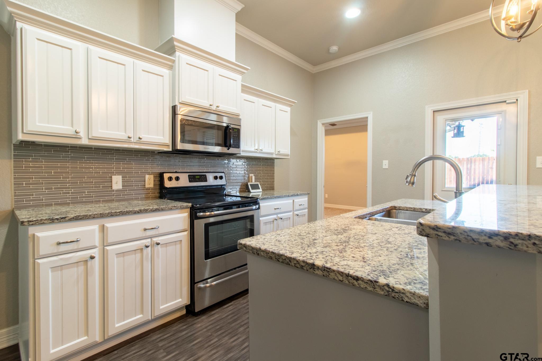 2806 Valley View Street Tyler, TX 75701 - Photo 8 of 22 a kitchen with stainless steel appliances granite countertop a sink and cabinets with wooden floor