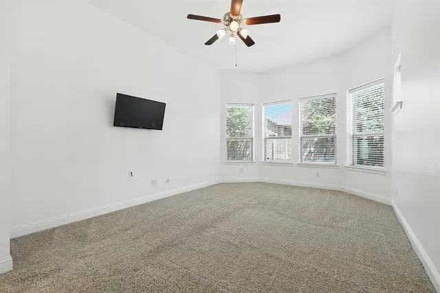 a spacious bedroom with a bed and a flat screen tv