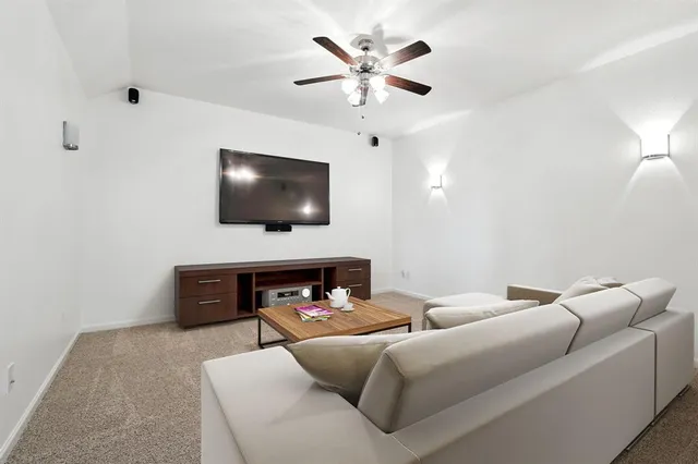 an empty room with chandelier fan