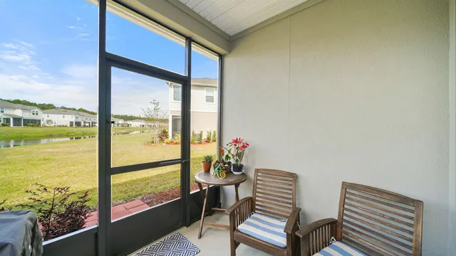 a view of a room with a large window and floor to ceiling window next to a yard