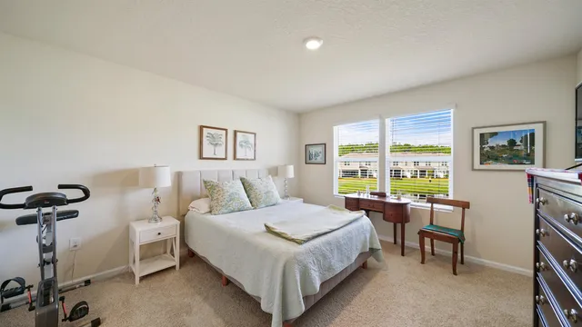 a bedroom with a bed and a large window