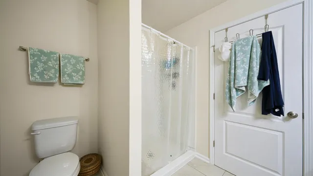 a bathroom with a shower a toilet a sink and mirror