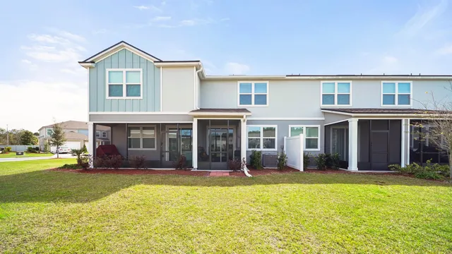 a front view of a house with a yard and palm trees