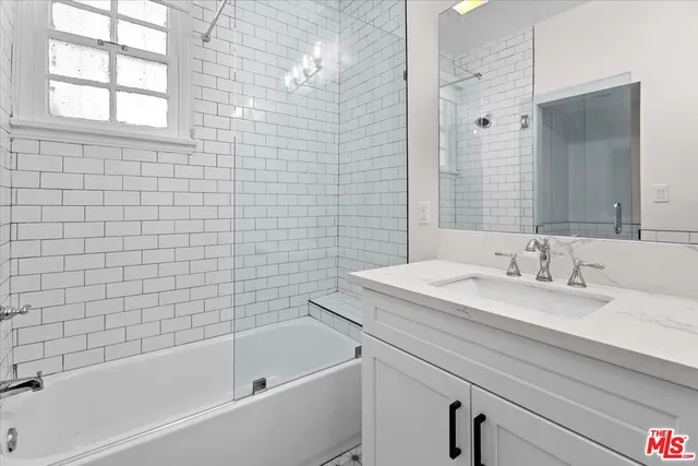a bathroom with a granite countertop sink a toilet and bathtub