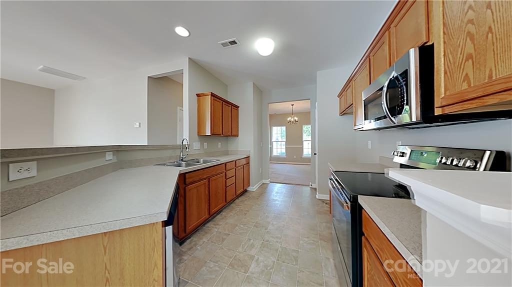 180 Snead Road Fort Mill, SC 29715 - Photo 4 of 15 a large kitchen with stainless steel appliances granite countertop a sink and a stove top oven with wooden floor