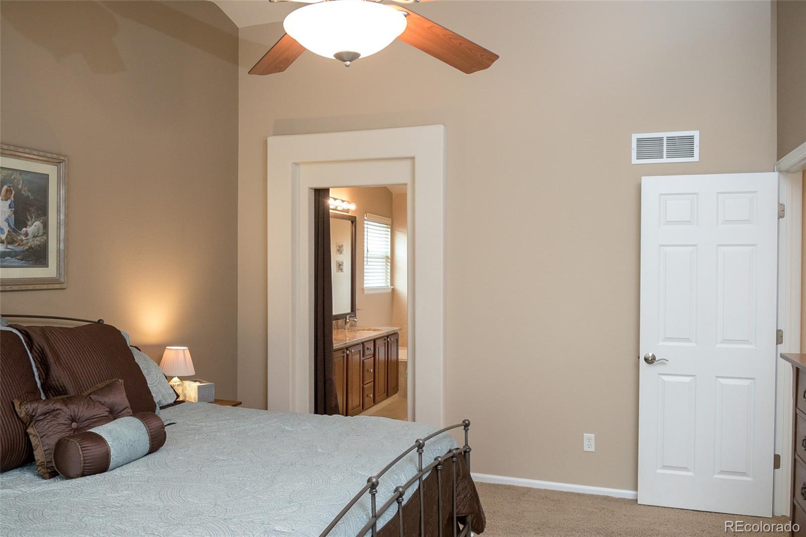 10221 South Nickolas Avenue Highlands Ranch, CO 80130 - Photo 17 of 35 a bedroom with a bed and a chandelier