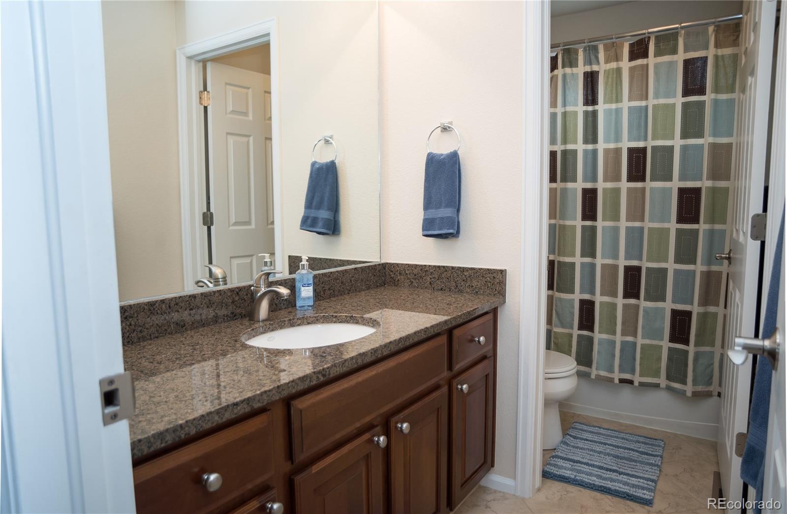 10221 South Nickolas Avenue Highlands Ranch, CO 80130 - Photo 23 of 35 a bathroom with a granite countertop sink and a mirror