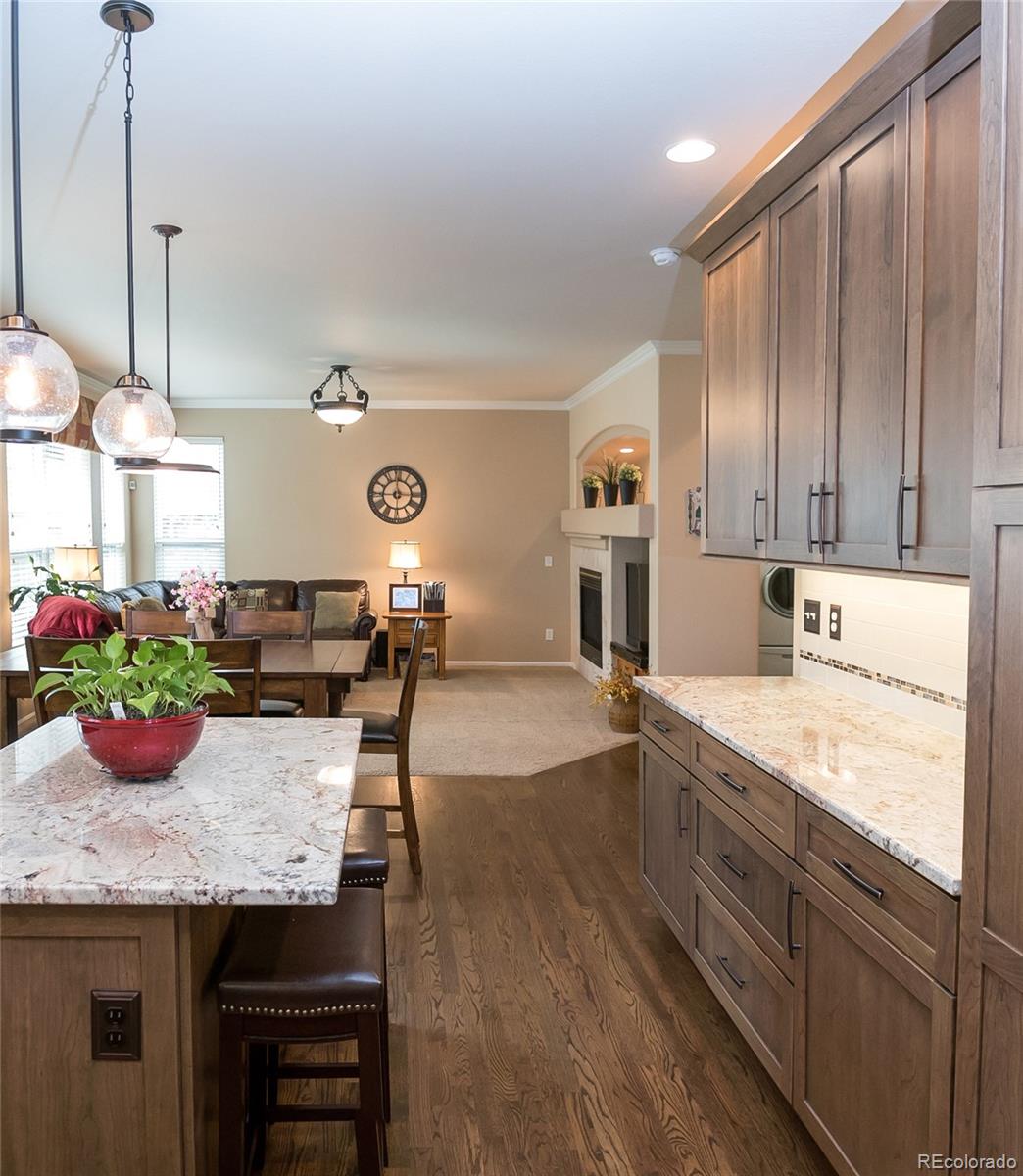 10221 South Nickolas Avenue Highlands Ranch, CO 80130 - Photo 7 of 35 a open kitchen with granite countertop a sink and white cabinets