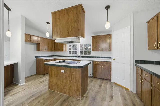 a kitchen with stainless steel appliances granite countertop a sink a stove and a wooden floors