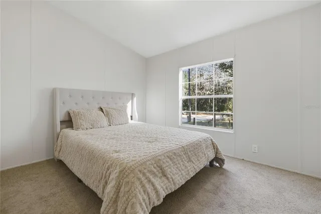 a large bed sitting in a bedroom next to a window