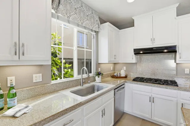 a kitchen with stainless steel appliances granite countertop a sink a stove and cabinets
