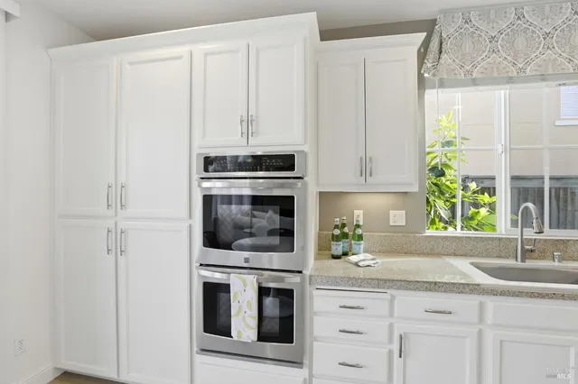 a kitchen with stainless steel appliances white cabinets and a sink