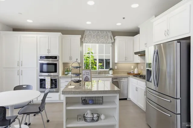 a kitchen with kitchen island a stove a sink and a refrigerator