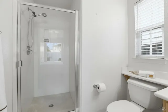 a bathroom with a granite countertop toilet a sink and shower