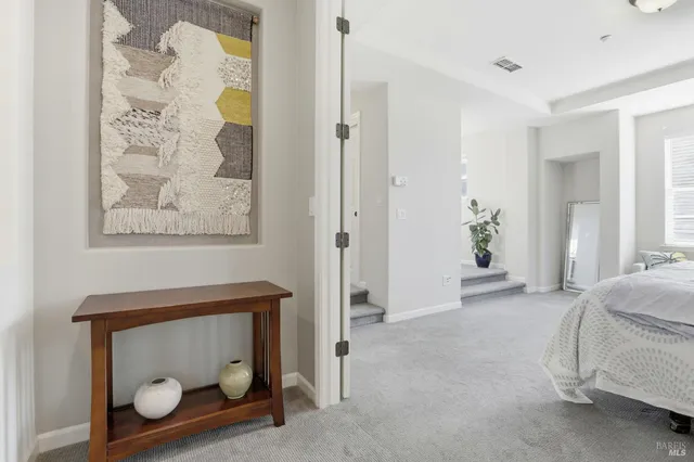 a bedroom with a bed and a painting on the wall