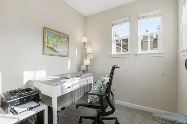 a view of a workspace with furniture and a window