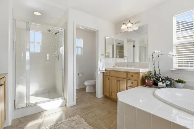 a bathroom with a double vanity sink mirror and shower