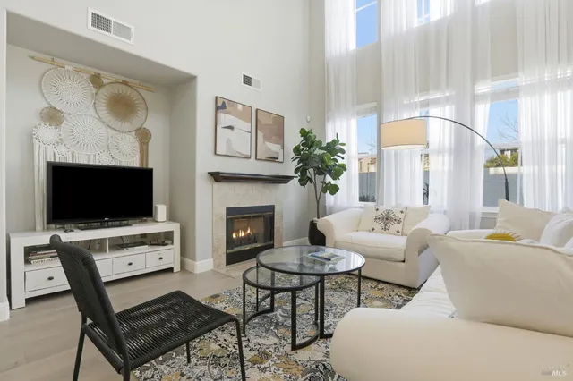a living room with furniture a flat screen tv and a fireplace