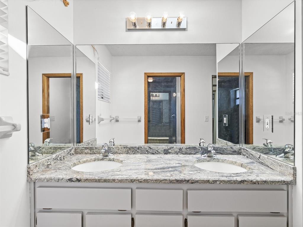 4290 Carlos Court Hernando Beach, FL 34607 - Photo 16 of 96 a bathroom with a granite countertop sink and a mirror