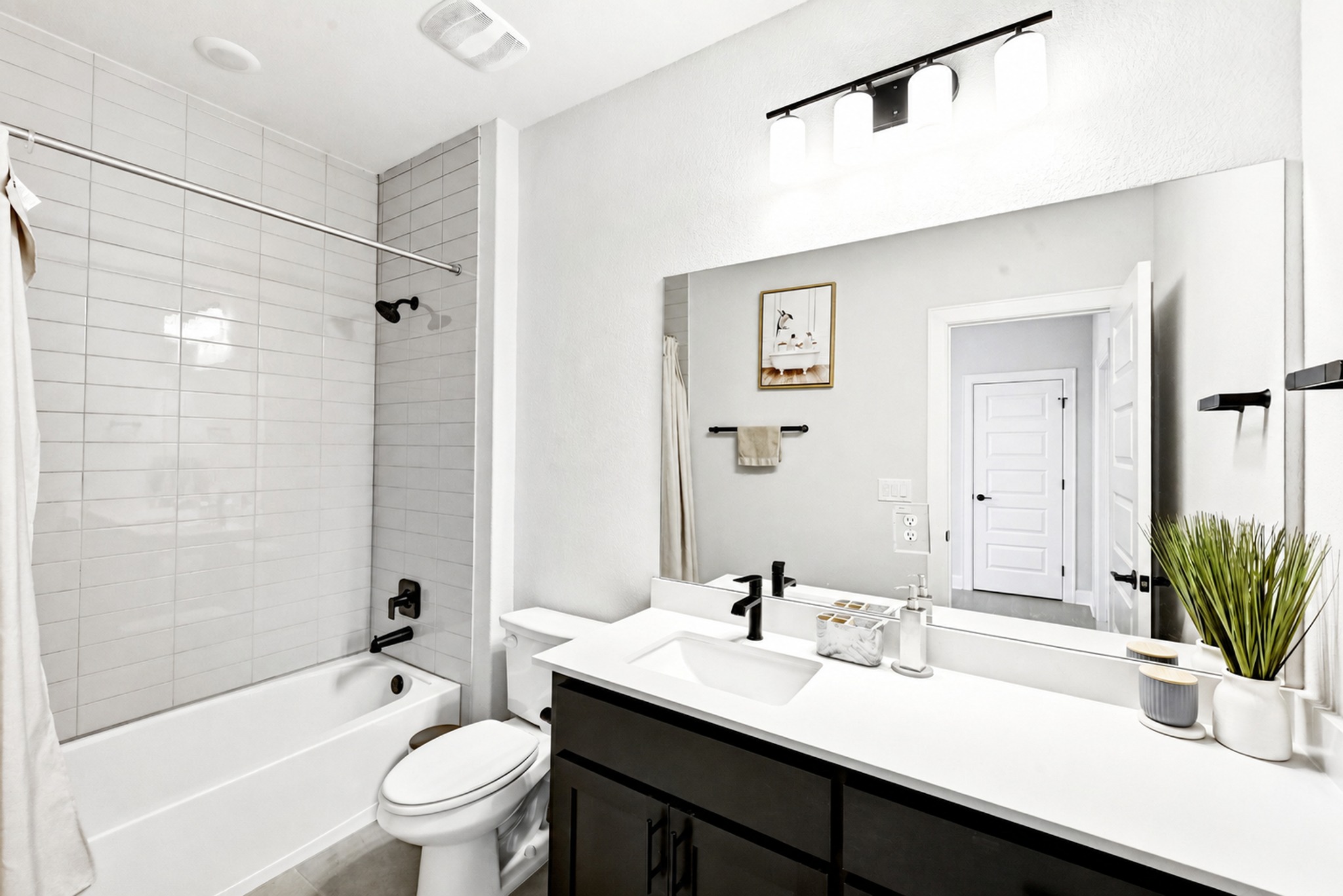 2702 Sebring Circle Austin, TX 78747 - Photo 24 of 35 Crisp subway tile surrounds the bath in this modern, neutral bathroom.