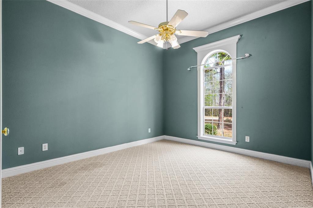 1304 Greenbriar Trail Holly Lake Ranch, TX 75765 - Photo 24 of 40 an empty room with windows and chandelier fan