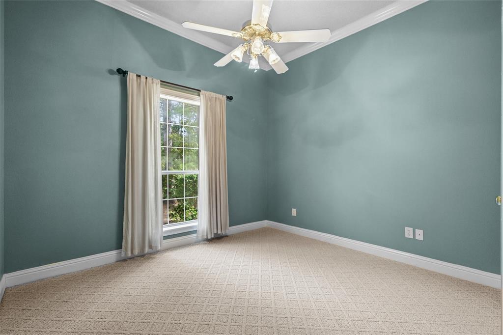 1304 Greenbriar Trail Holly Lake Ranch, TX 75765 - Photo 25 of 40 an empty room with a chandelier fan and windows