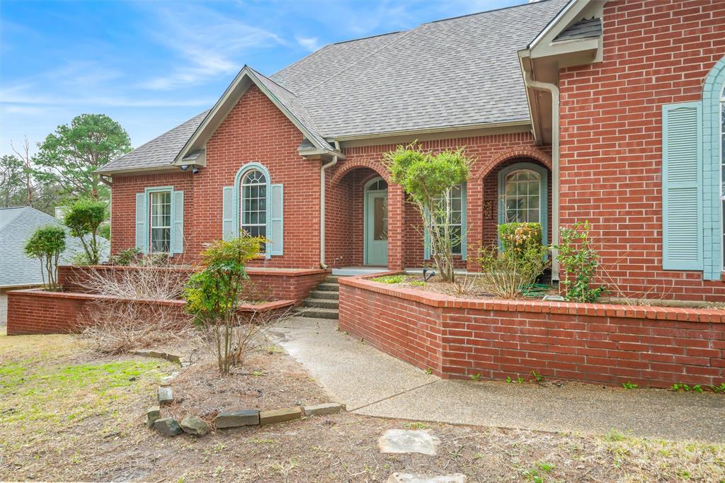 1304 Greenbriar Trail Holly Lake Ranch, TX 75765 - Photo 3 of 40 a front view of a house with garden