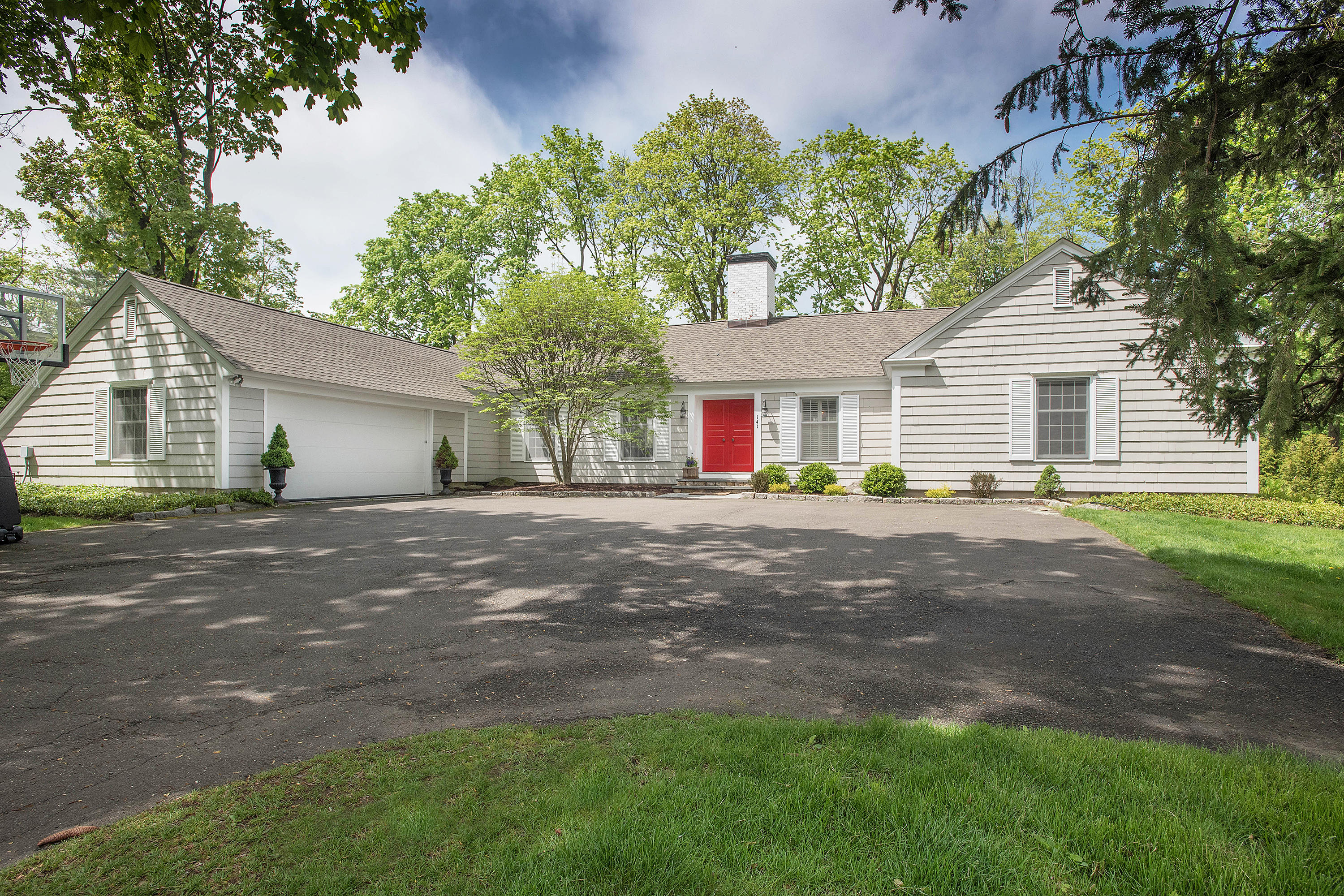 141 Oenoke Ridge New Canaan, CT 06840 - Photo 1 of 18 a front view of a house with a garden and yard