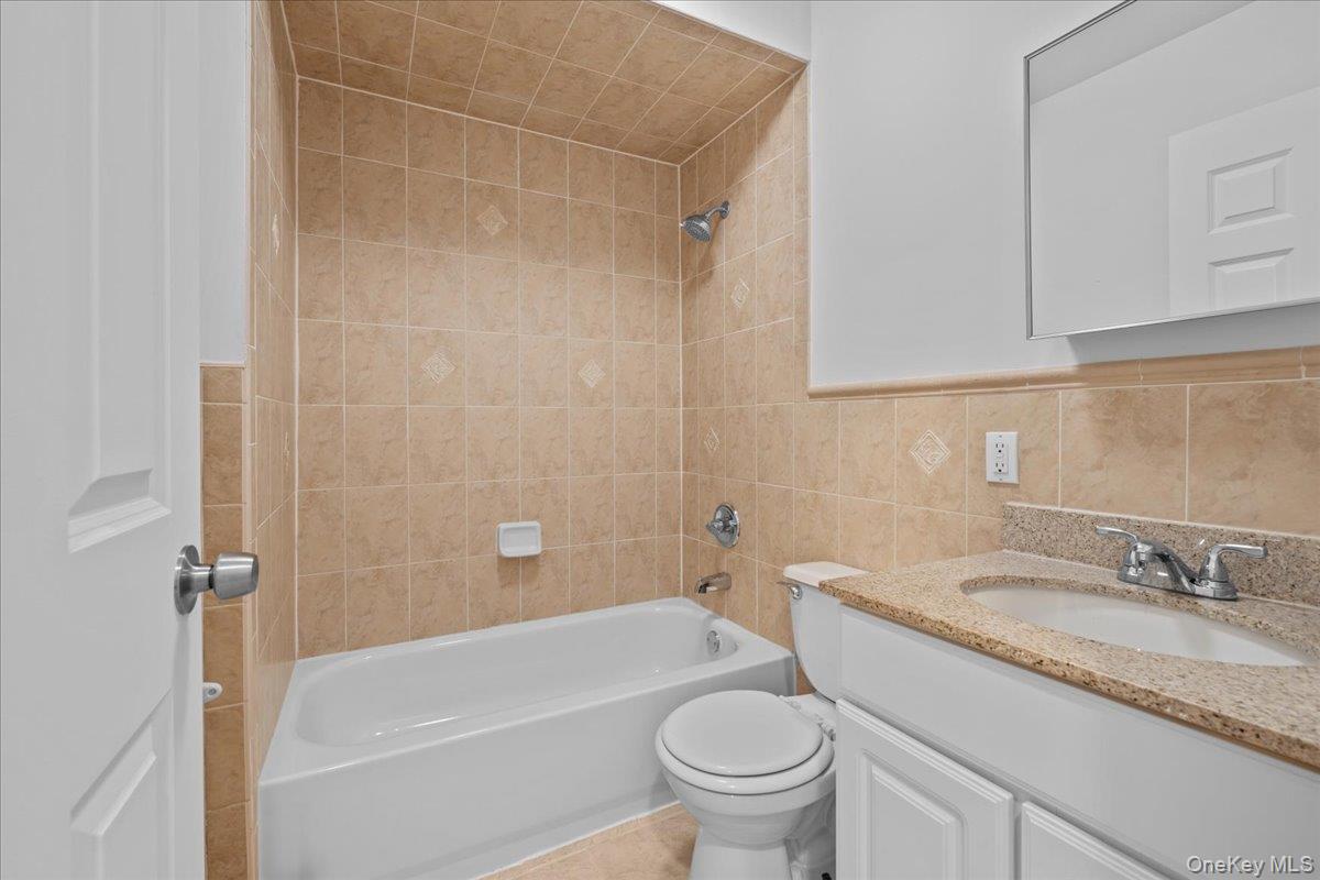 126 Beach 92nd Street, Unit 3C Queens, NY 11693 - Photo 5 of 16 a bathroom with a granite countertop sink a toilet and bathtub