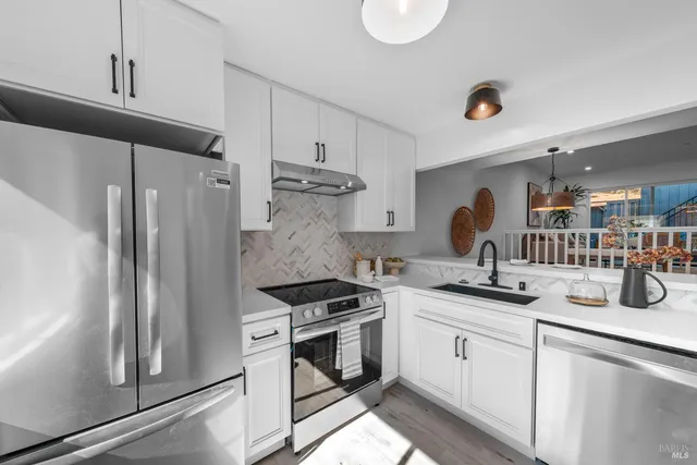 a kitchen with white cabinets and white appliances